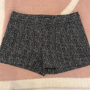 Express black and white polyester zip up shorts with cuffs and pockets.